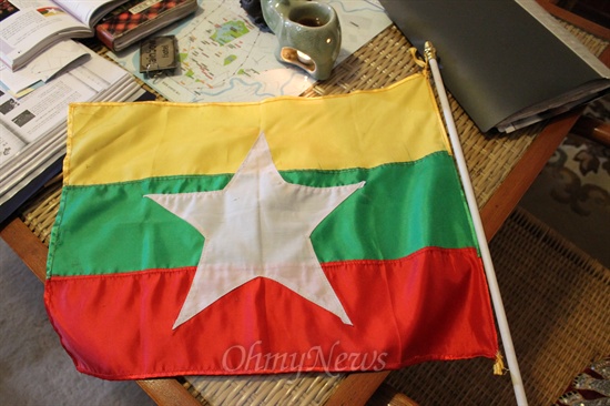 '미얀마 국기'인 Naingandaw Alin(나잉강도 얼링). 2010년 11월 7일 총선을 앞두고 10월 21일 전격 변경되었다. 맨 위의 노랑 바탕은 단결을, 중간의 녹색은 평화를, 맨 아래 붉은색은 용기를 나타낸다. 국기변경은 2008년 국민회의에 의하여 만들어진 신헌법 의결에 의해 개정되었다. 