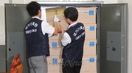  국가기록원 관계자들이 18일 오후 국회 운영위 소회의실에 마련된 2007년 남북정상회담 자료 열람실 금고에 관련 자료를 옮기고 있다.