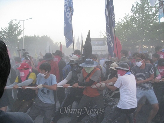 20일 현대차 울산 공장 철조망을 뜯어내려는 집회 참가자들이 철조망을 묶음 밧줄을 당기고 있다. 