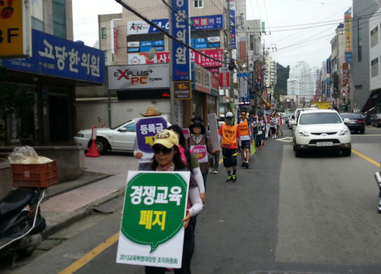  24일 울산에 온 교육혁명전국대장정이 울산조직위원회와 함께 울산교육청 인근 중구 유곡동 거리에서 '경쟁교육 폐지' 등을 시민들에게 홍보하며 행진하고 있다
