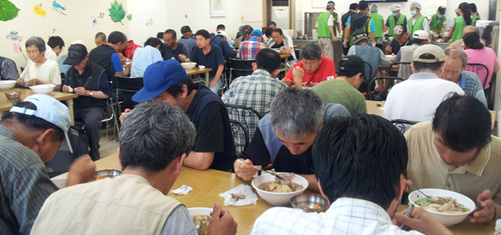 26일 저녁 서울역 따스한 채움터에서 노숙인들이 예배를 마치고 삼계탕을 시식하고 있다.