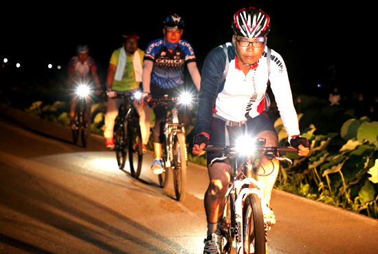 30일 밤 경남 함양군 상림연꽃단지 도로에서 자전거동호인들이 자전거 전조등을 켜고 라이딩을 즐기고 있다.