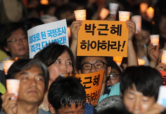 3일 오후 서울 청계광장에서 국정원 시국회의가 주최한 제5차 국민촛불대회에서 일부 참가자들이 박근혜 대통령의 하야를 주장하는 피켓을 펼쳐 들고 있다.