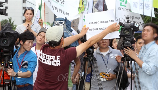 3일 오후 서울 청계광장에서 열린 '민주주의 회복과 국정원 개혁'을 위한 민주당 국민보고대회에 참가한 한 시민이 "KBS, MBC, YTN, 종편, 조중동의 취재를 거부한다"며 피켓으로 카메라 앞을 막고 있다. 