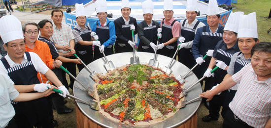  3일 경남 함양군 천년의 숲 상림공원 일원에서 열리고 있는 제10회 함양산삼축제에서 임창호 군수, 정욱상 함양산삼축제위원장 등 관계자들이 산삼비빔밥 500인분을 주걱으로 비비고 있다.