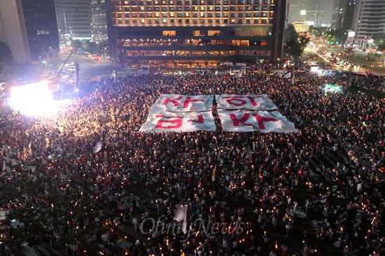 촛불의 바다에 띄운 '민주주의' 10일 오후 서울시청앞 서울광장에서 국정원 대선개입 규탄 제6차 범국민대회가 열린 가운데 촛불을 든 수만명 시민들이 '민주주의'가 적힌 대형현수막을 펼쳐들고 있다.