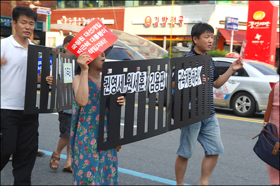 "권영세, 원세훈, 김용판을 구속 처벌하라"는 감옥모형의 피켓을 들고 행진하는 시민들