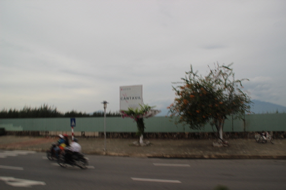 다푸옥 프로젝트 현장에 펜스가 처져 있고, 그 위로 대원 칸타빌 광고판이 보인다.