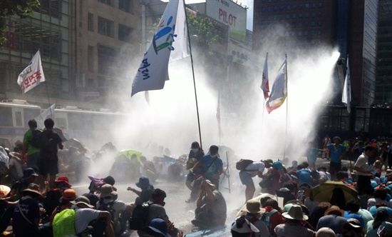 15일 오후 박근혜 정권 규탄 국민대행진 참가자들이 서울 종로 보신각 앞 도로에서 기습 연좌 농성을 벌이자 경찰이 물대포를 쏘고 있다.
