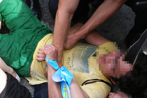 기습시위 참가자가 강제 연행되지 않기 위해 안간힘을 쓰고 있는 모습.