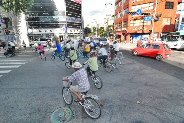 자전거와 차들이 도로를 질주 해 인근 주차장으로 옮겨가고 있다