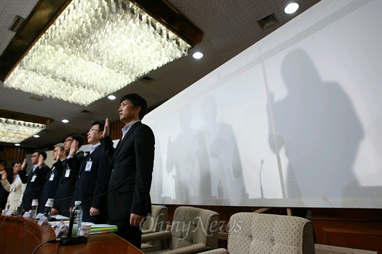 19일 오전 국정원 댓글 의혹 사건 등을 다루는 국정원 국조특위 청문회에 출석한 국정원 박원동 전 국익정보국장과 김하영씨가 다른 증인들과는 달리 가림막 뒤에서 증인선서를 하고 있다.