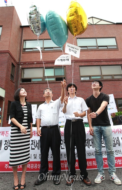   2013년 3월 22일 오전 서울 종로구 청와대 인근 청운동 동사무소 앞에서 열린 '박근혜 정부의 신규 전세대출 확대안을 비판 및 제대로 된 전월세 대책 촉구 기자회견'에서 제윤경 금융정의 연대 상임이사(사진 왼쪽부터)와 최창우 전국세입자협회 공동대표, 이선근 민생연대 대표를 비롯한 회원들이 치솟는 전월세 문제의 해결을 촉구하는 퍼포먼스를 벌이고 있다. 