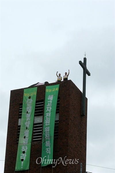 여민희(왼쪽), 오수영 조합원이 23일 오전 서울 종로구 혜화동성당 종탑 위에 서 있다.