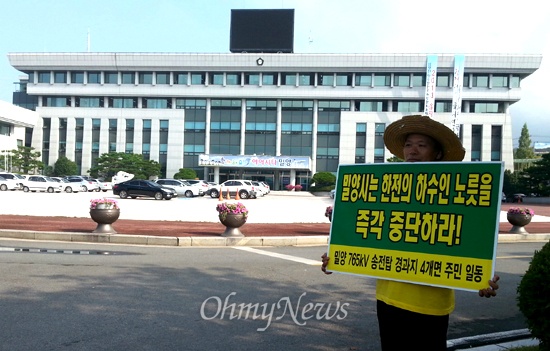  한 시민이 밀양시청 앞에서 송전탑 반대 피켓을 들고 시위를 하고 있다. 