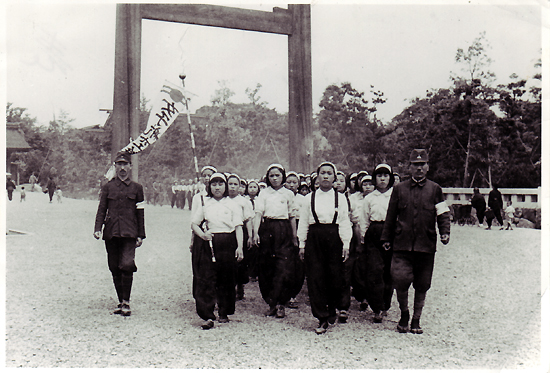 1944년 6월경 미쓰비시중공업 나고야 항공기제작소에 동원된 어린 여자근로정신대원들이 일본인 인솔자를 따라 깃발을 앞세우고 신사참배에 나서고 있다.