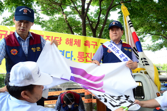 재향군인회 회원이 대방동 통합진보당 당사 앞 기자회견에서 퍼포먼스로 통합진보당 깃발을 찟고있다.