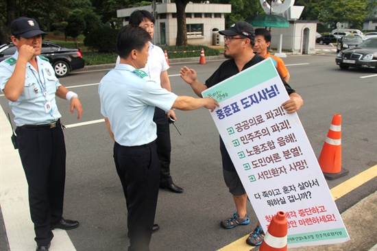  박석용 전국보건의료산업노동조합 진주의료원지부장이 30일 오후 경남도청 정문 쪽에서 홍준표 경남지사를 비난하는 내용의 피켓을 들고 도청 현관 앞으로 이동해 1인시위를 벌이려고 하자 도청 관계자들이 나와 들어가지 못하도록 하면서 실랑이가 벌어졌다.