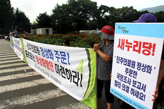  전국보건의료산업노동조합 진주의료원지부 조합원들이 30일 오후 경남도청 정문 앞에 진주의료원 재개원 등을 촉구하는 내용의 펼침막과 피켓을 들고 서 있다.