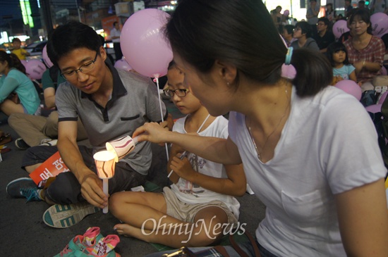 구미역 앞에서 30일 오후 열린 국정원 정치개입 규탄 촛불문화제에 참가한 가족이 촛불을 서로 붙이고 있다.