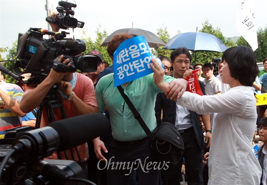 31일 오후 서울 강남구 내곡동 국정원 앞에서 열린 '국정원 내란음모 조작, 공안탄압 규탄대회'에서 한 참가자가 <채널A>의 내란예비음모 혐의 수사 취재보도에 항의하며 손피켓으로 카메라를 가리고 있다.