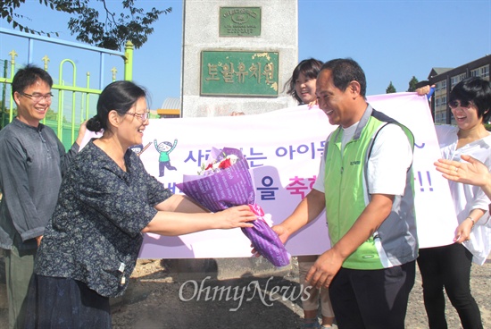  '교사 시국선언'과 '정당후원' 등으로 징계를 받았던 안호형 교사가 부당징계소송에서 승소한 뒤 2일 오전 차원 토월초등학교 병설유치원에 첫 출근하면서, 송영기 전교조 경남지부장으로부터 꽃다발을 받고 있다.