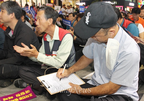 7일 저녁 부산 서면에서는 국정원의 대선개입 사건을 규탄하고 특별검사 도입을 촉구하는 8차 시국대회가 열렸다. 시국대회가 열리는 도중 한 시민이 특검 도입을 촉구하는 서명지에 서명하고 있다. 