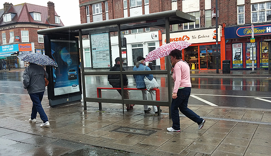 인도계와 서남아시아 이주민들이 많이 살고 있는 런던 북부지역. 비가 내리는 거리를 걷고 있는 사람들과 버스를 기다리는 사람들이 스치고 있다. 