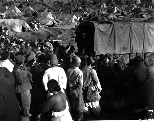 피난민촌에 미군 구호차가 오자 피난민들이 몰려들고 있다(경기도 파주, 1953. 1. 29.). 