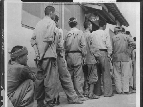 부산포로수용소에서 포로들이 의무대 앞에서 줄을 서서 기다리고 있다(1950. 8. 25.)