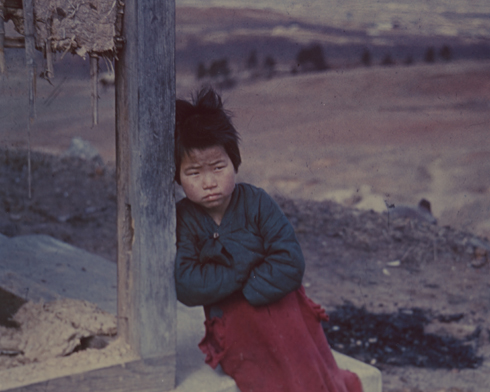 한 소녀가 전란으로 허물어진 집 섬돌에 앉아서 배고픔과 추위에 떨고 있다(전주, 1951. 3. 1.). 
