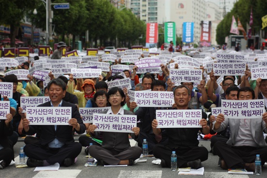 통합진보당 이정희 대표와 김선동 국회의원을 비롯해 집회 참가자들이 '국가산단의 안전은 국가가 책임져라'는 섹션을 펼치고 있다.