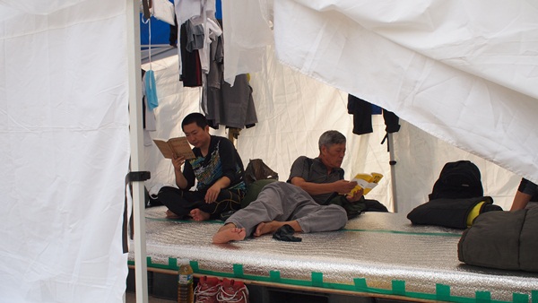 조희주 노동전선 대표와 정진우 노동당 부대표가 대한문에 나가기 전 천막에 나란히 앉아 책을 읽고 있다.