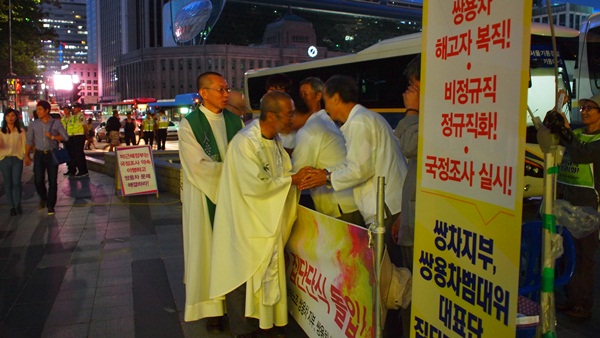 "평화를 빕니다" 천주교 사제들은 투쟁하는 노동자들의 손을 정성들여 잡아주며 용기를 북돋워 준다.