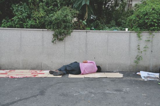 종이 박스 한 장에 의지해 누워있는 노숙인의 모습. 