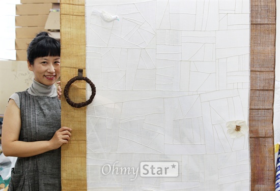  섬유디자이너 이해은씨가 6일 오전 서울 목동에 위치한 작업실에서 오마이스타와 인터뷰를 마친 뒤 자신의 작품을 보여주며 미소짓고 있다.