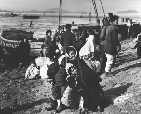 강추위 속에 피난민들이 나룻배를 타고자 한강 둔치에서 뱃사공을 기다리고 있다(서울, 1951. 1.).