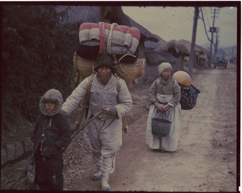 노인 부부가 어린 손자를 앞세우고 가재도구를 지고서 피난길에 나서고 있다(전주, 1951. 3. 1.).