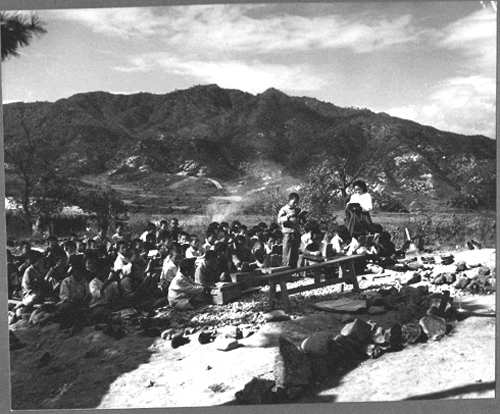 초등학교 학생들이 학교가 불타버린 곳에서 야외수업을 받고 있다(서울, 1953. 10.).