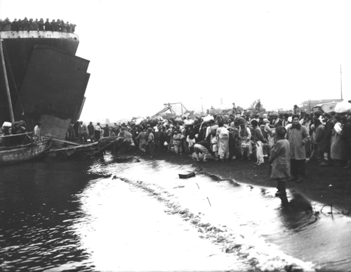 철수하는 유엔군 수송선(LST)을 타고자 부두에서 발을 동동 구르는 피난민들(흥남, 1950. 12. 19.). 