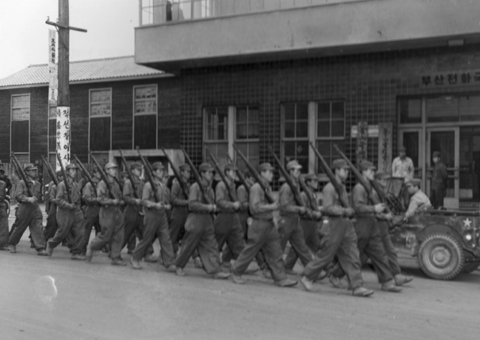 훈련병들이 어깨총을 한 채 부산전화국 앞을 지나고 있다(부산, 1951. 1. 8.).