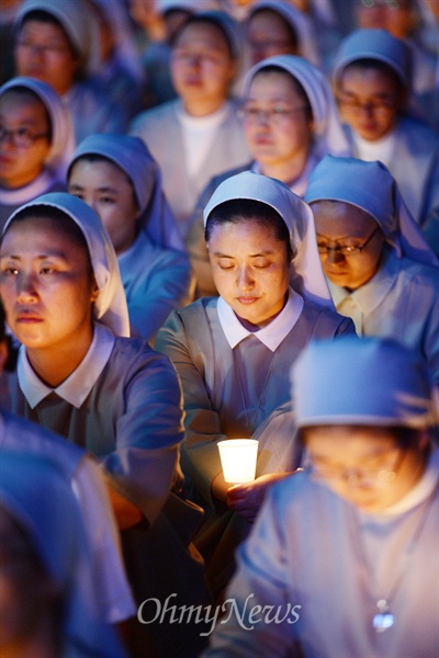 천주교정의구현전국사제단이 23일 서울광장에서 '국정원 해체 민주주의 회복 시국미사'를 연 가운데 한 수녀가 촛불을 켜고 미사에 참여하고 있다.