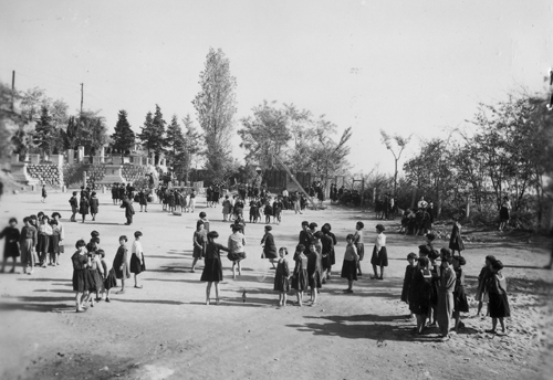 한 초등학교 어린이들이 운동장에서 뛰놀고 있다(원산, 1950. 11. 1.). 