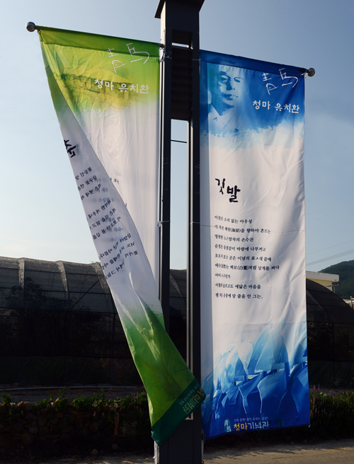 코스모스 꽃길이 끝나는 지점에 청마의 시 '깃발'이 새겨진 깃발이 바람에 나부끼고 있다.
