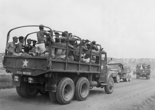 인민군 포로들이 그동안 유엔군에서 지급하여 입었던 옷을 벗어 던진 뒤 팬티차림으로 트럭을 타고 북에 돌아가고 있다(판문점, 1953. 8. 11.).