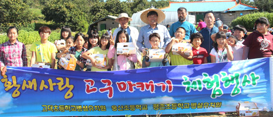 고구마캐기 행사에 참여한 어린이들이 황새사랑연구회 회원들과 기념사진을 찍고 있다. 
