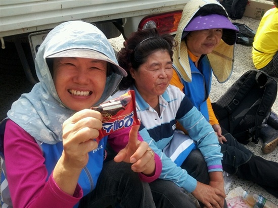 한국전력공사가 송전탑 공사를 재개한 가운데 1일 오전 밀양시 단장면 바드리 마을 입구에서 주민들이 공사장비 진입을 막으며 앉아있다. 주민들이 식사 대용으로 오예스를 먹고 있다.
