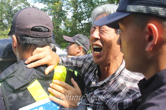  한국전력공사가 밀양 송전탑 공사 재개를 위해 1일 장비와 인력을 현장이 투입한 가운데, 이날 오전 밀양시 단장면 바드리 마을 철탑 현장 입구에는 주민 30여명이 모여 장비 진입 등을 막으며 경찰과 대치하거나 충돌했다. 사진은 교장 출신인 고준길(71)씨가 진입을 막는 경찰에 고함을 지르며 호소하고 있는 모습.