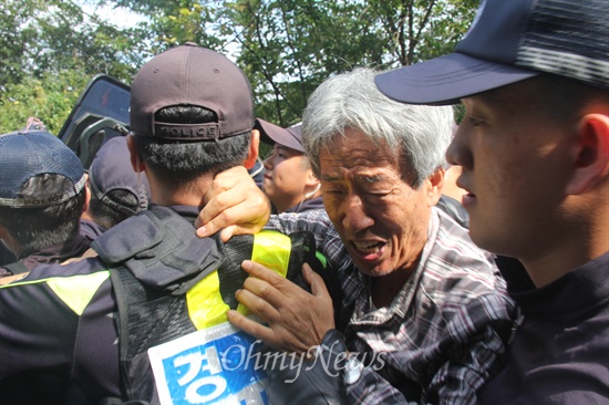  한국전력공사가 밀양 송전탑 공사 재개를 위해 1일 장비와 인력을 현장에 투입한 가운데, 이날 오전 밀양시 단장면 바드리 마을 철탑 현장 입구에는 주민 30여 명이 모여 장비 진입 등을 막으며 경찰과 대치하거나 충돌했다. 사진은 교장 출신인 고준길(71)씨가 진입을 막는 경찰에 고함을 지르며 호소하고 있는 모습. 
