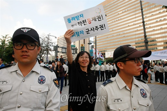 평화와통일을여는사람들(평통사) 회원들이 '건군 제65주년 국군의 날' 기념 시가행진이 열리는 1일 오후 서울 세종로 네거리에서 '전시작전통제권 환수' 촉구 시위를 벌이고 있다.